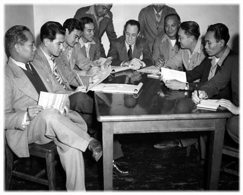 Longshore union negotiating committee seated around a table reviewing documents